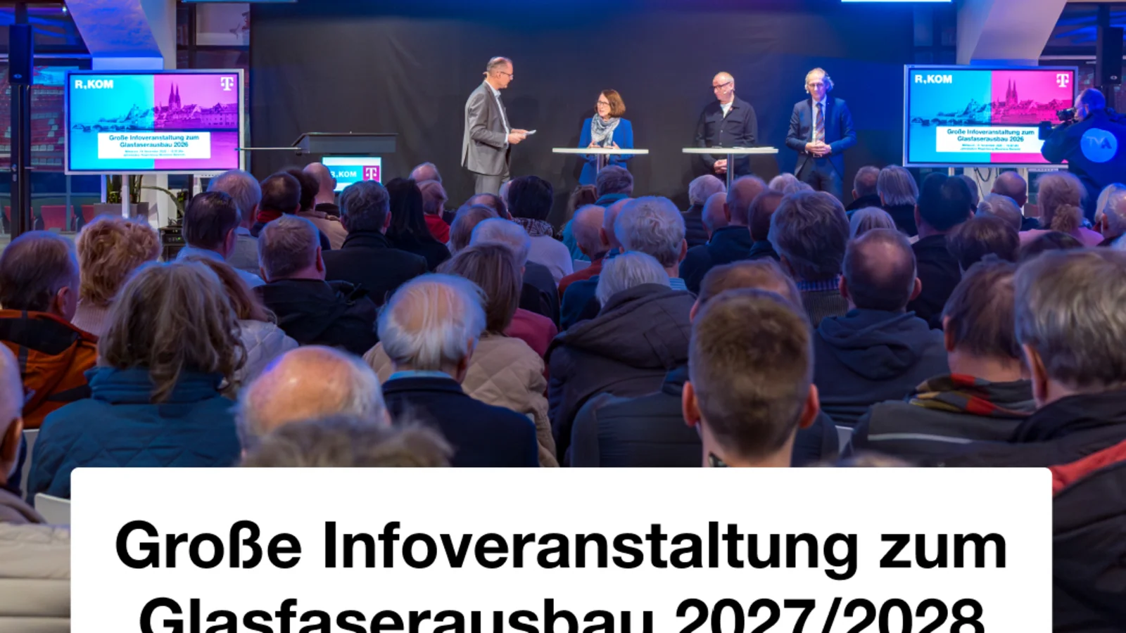 Podium vor vollem Saal bei der Infoveranstaltung zum Glasfaserausbau