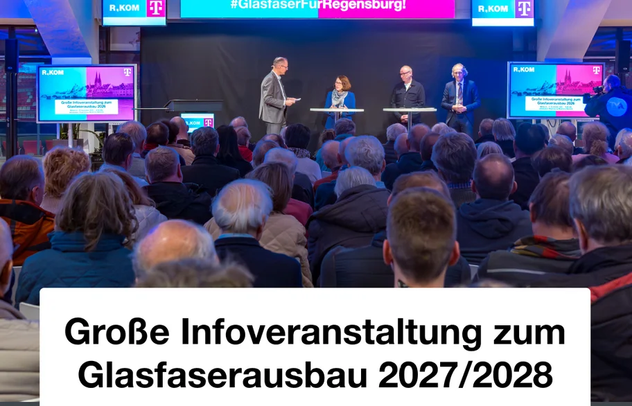 Podium vor vollem Saal bei der Infoveranstaltung zum Glasfaserausbau