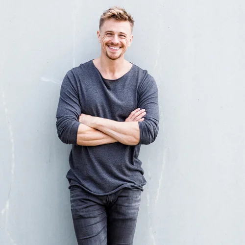 Das Bild zeigt den Künstler vor neutralem Hintergrund.