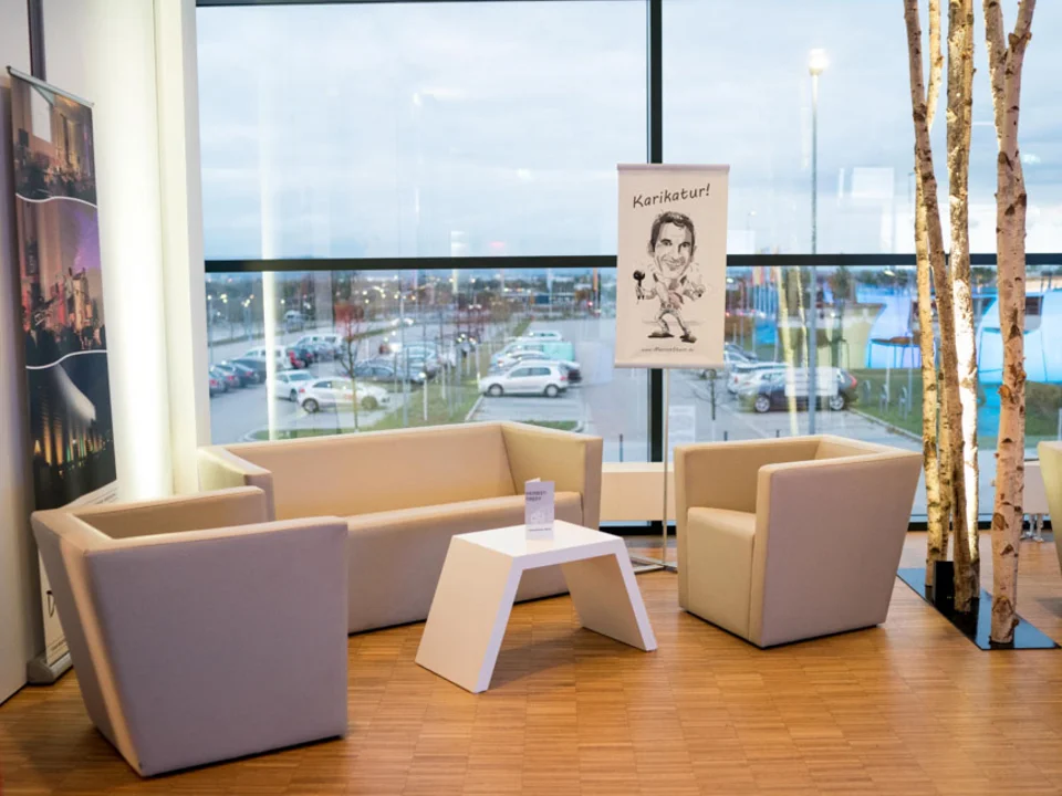 Lounge mit Sesseln vor dem Panoramafenster
