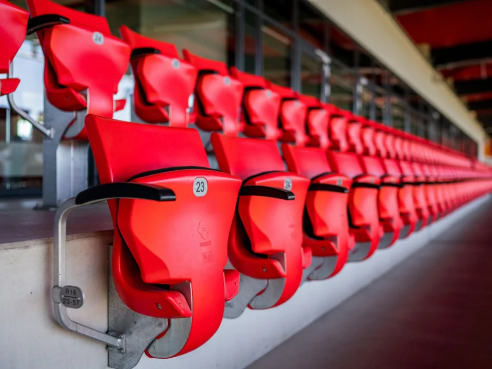 Rote Sitzschalen in einer Reihe auf der Tribüne