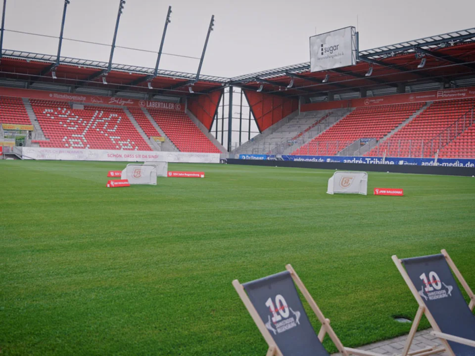 Liegestühle auf dem Rasen mit Blick auf die Tribüne