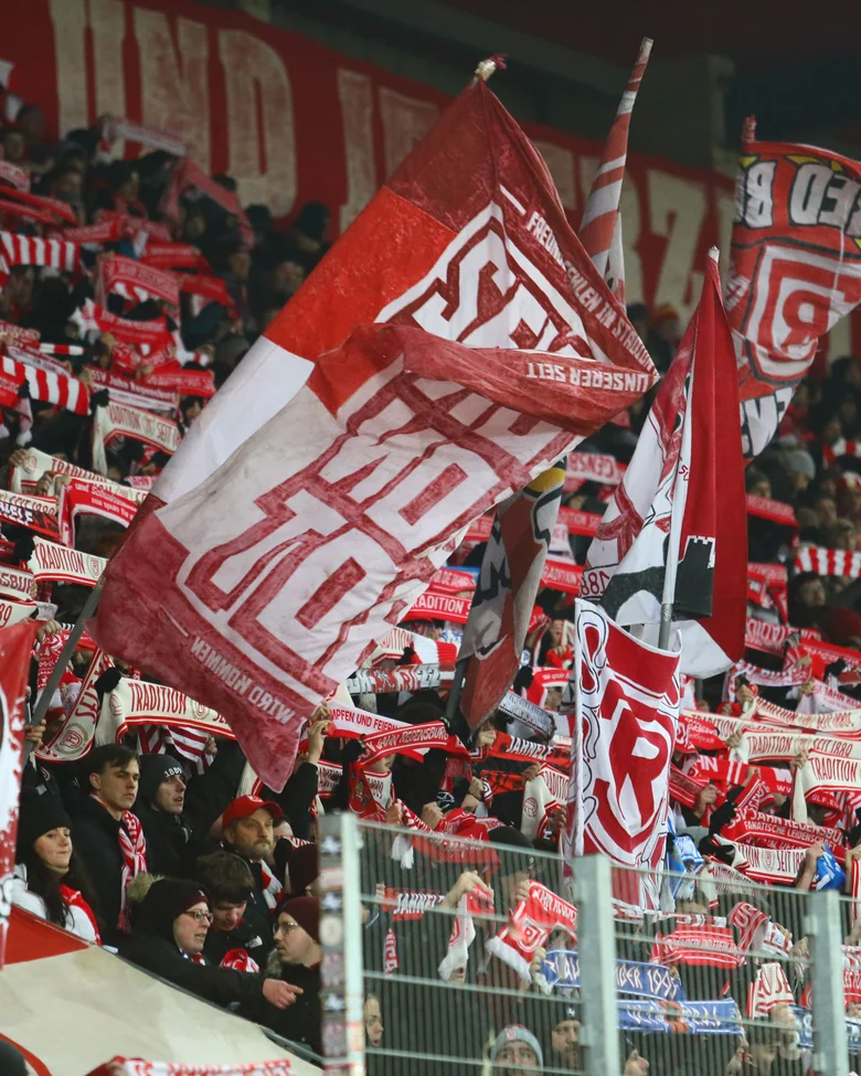 Fans mit Fahnen in der Kurve beim Heimspiel des SSV Jahn
