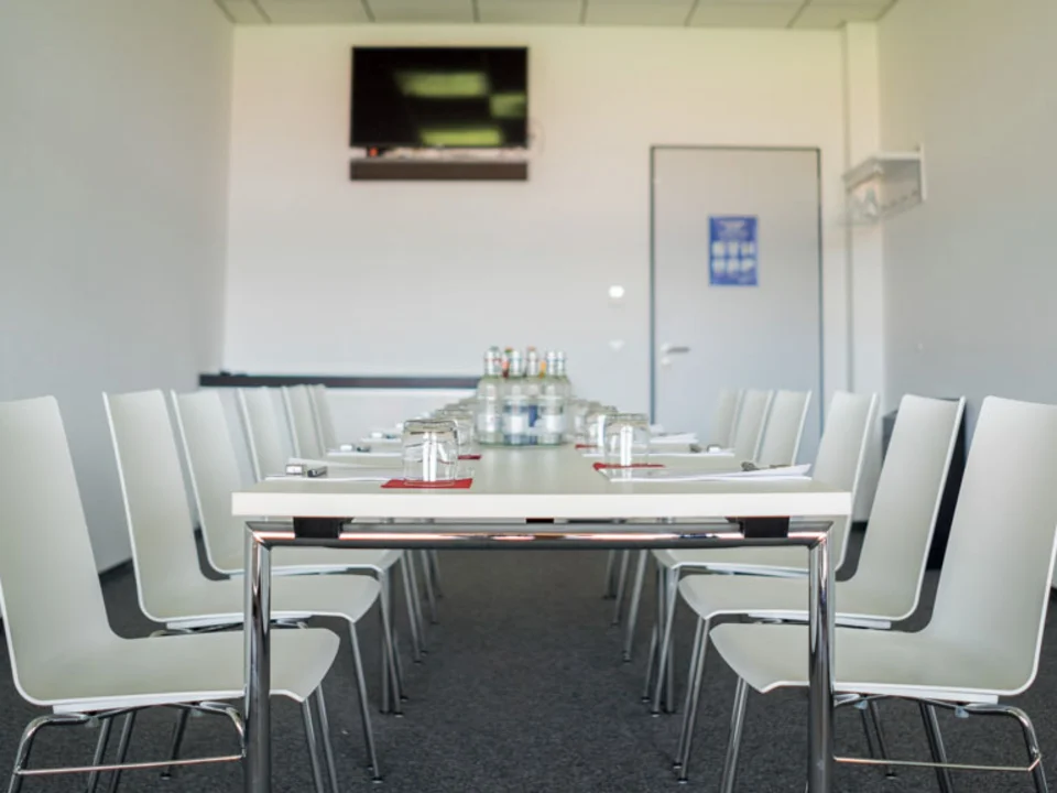 Besprechungstisch mit weißen Stühlen in einer Loge