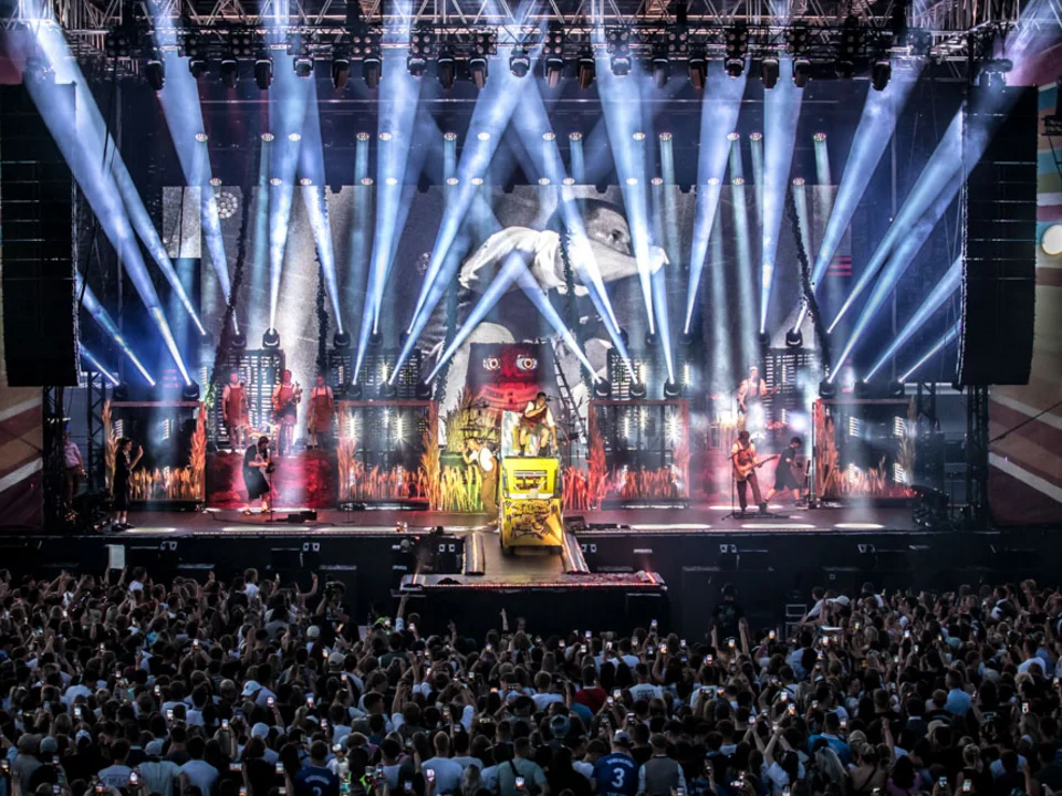 Konzertbühne mit Lichtshow vor vollem Innenraum