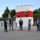 Man sieht fünf Personen die mit Abstand vor einem Rot-Weißen Turm stehen.