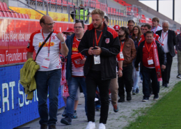Man sieht eine Gruppe Menschen, die durchs Jahnstadion geführt werden.