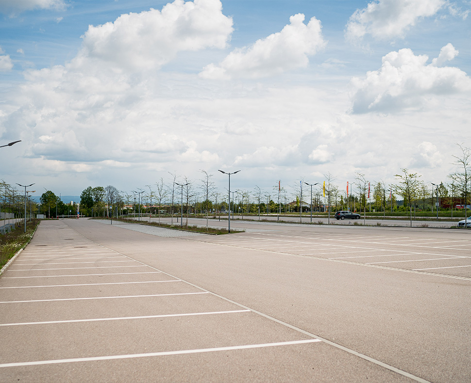 Man sieht eine leere Parkplatzfläche.