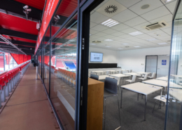 Man sieht den Blick vom Balkon im Jahnstadion, auf der einen Seite in einen Tagungsraum mit Plenarbestuhlung und auf der anderen Seite auf die Tribüne mit roten Stühlen.