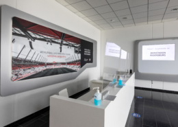 Man sieht den weißen Eingangstresen im Jahnstadion auf dem Desinfektionsmittelspender stehen und eine Plexiglasscheibe aufgebaut ist.