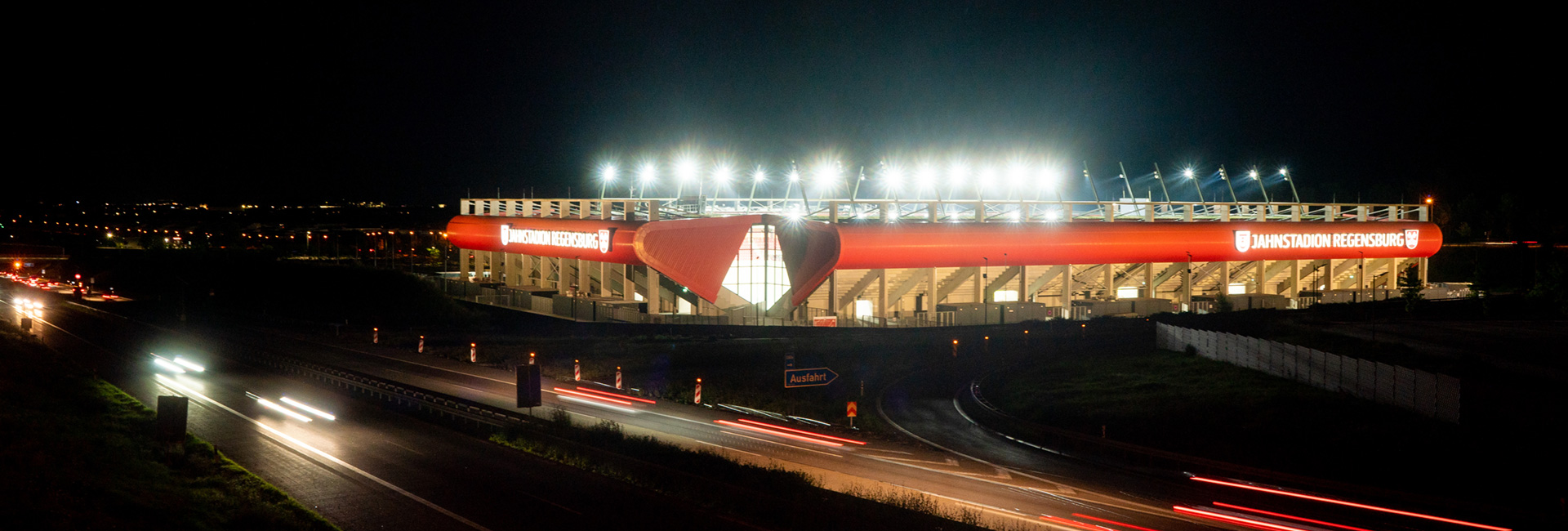 Man sieht einen Nachtaufnahme des Jahnstadions mit Flutlichtbeleuchtung.