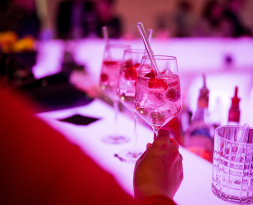 Man sieht drei Cocktails auf einer Bartheke.
