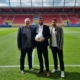 Zwei Vertreter des BFV überreichen Sebastian Graf auf dem Spielfeld im Jahnstadion Regensburg einen Fußball.